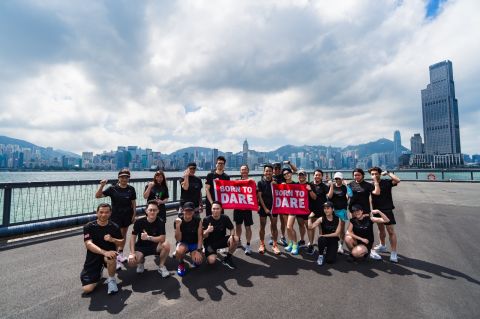Tudor x Chow Tai Fook Born To Dare running event — group photo with the Hong Kong skyline